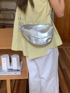Silver metallic crescent shoulder bag detail view, stylish underarm crescent bag for women.