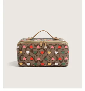 Large capacity travel cosmetic bag with cute heart print and top handle for women daily use.
