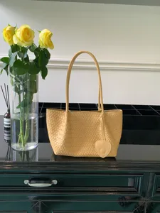Luxury woven shoulder bag in soft cream yellow with heart pendant, large capacity daily tote.