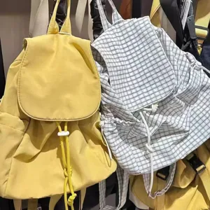 Nylon drawstring flap backpack detail shot showing yellow and plaid casual daily school bag