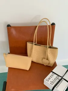 Spacious cream woven tote bag set with matching pouch and heart charm for daily chic style.