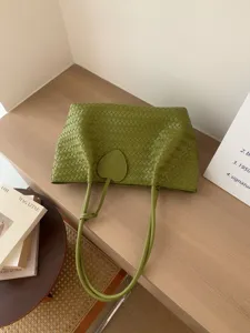 Green woven shoulder tote bag for women, stylish large capacity casual handbag with charm.