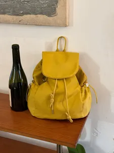 Casual yellow nylon backpack with drawstring flap closure, lightweight and stylish daily commuter bag.