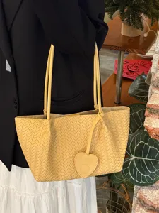 Light luxury woven shoulder bag in tender yellow with cute heart pendant, large tote design.