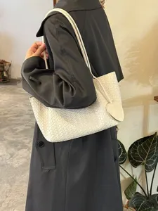 Casual woven shoulder bag for women, stylish white tote bag with cute heart pendant accessory.