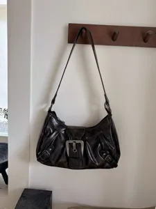 Vintage distressed brown hobo shoulder bag detail, Y2K retro underarm handbag close-up view.