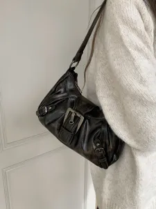 Close-up detail of the vintage distressed brown shoulder bag showcasing the metal buckle and hardware.