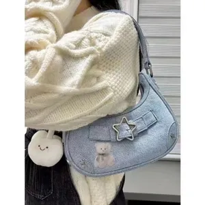 Close-up of retro denim shoulder bag featuring a cute star buckle and bear detail.