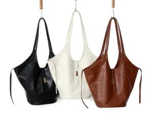 Detailed close-up shot of three stylish slouchy leather tote bags in black, white, and brown.