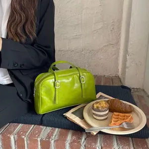 Green leather handbag detail showcasing retro belt buckle design and stylish lifestyle scene.