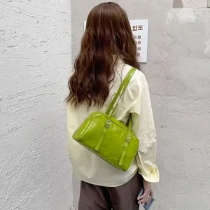 Green leather underarm shoulder bag with belt and metal buckle detail for commute wear.