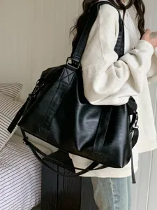 Detail view of the large capacity black PU leather travel duffel gym bag with multi-way straps.
