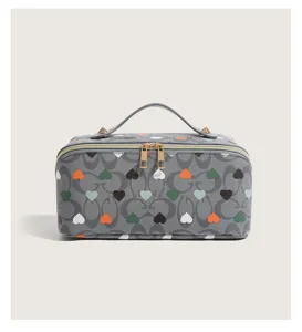 Grey heart print cosmetic bag with top handle and double zipper for travel and daily use.