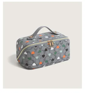 Grey heart print cosmetic bag detail, featuring double zippers, sturdy handle, and spacious interior.