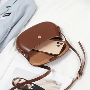 Brown PU leather saddle bag for women, stylish crossbody phone bag with magnetic snap closure.