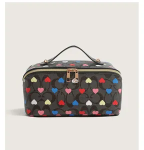 Large capacity cosmetic bag with stylish monogram and colorful heart print design for travel.