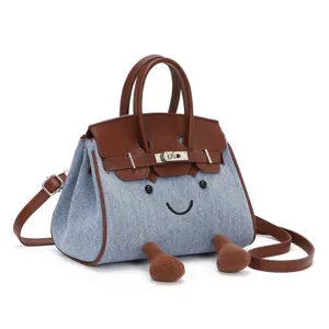 Detailansicht der Jeans und brauen Leder Handtasche mit niedlichem Gesicht und Metallschloss.