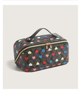 Detailed close-up view of the heart-printed cosmetic bag, highlighting smooth zippers and texture.
