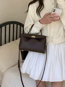 Gros plan d'un sac à main rétro en cuir PU marron avec fermoir métallique et bandoulière.