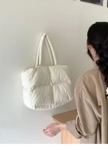 Detailansicht der weißen Daunen-Stepptasche mit weicher Wattierung und minimalistischem Design.