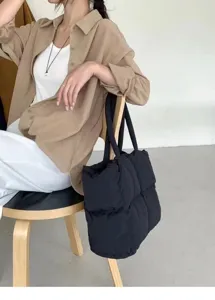 Schwarze Puffer Tote Tasche Detail, leichte Wolken Schultertasche, minimalistisch Alltag.