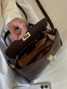 Vue détaillée de l'intérieur du sac en cuir PU marron avec doublure douce et quinzaine dorée.