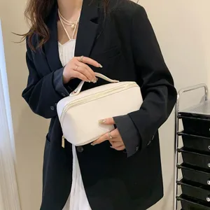 Trousse de maquillage blanche minimaliste portable, grande capacité étanche pour accessoires.