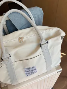 Minimalist large capacity travel duffel bag with trolley sleeve and durable handles for women