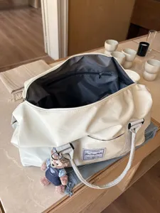 Detailed view of the large capacity canvas travel duffel bag interior and front pocket.