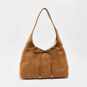 Detailansicht der braunen Wildleder-Schultertasche mit eleganter Leder-Schleife.