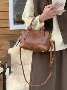 Retro brown bowling bag for women, fashion PU leather handbag with shoulder strap and top handle.