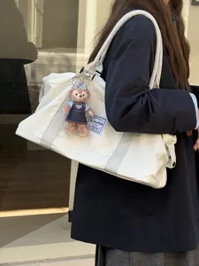 Large capacity white travel bag with cute plush keychain, casual shoulder duffel for women.