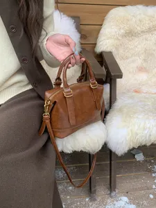 Retro brown bowling shoulder bag detail shot showcasing fine leather texture and metal hardware.