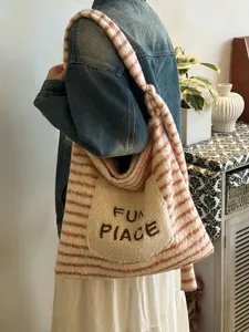 Detailed view of the striped plush tote bag with embroidered pocket, showing soft texture.