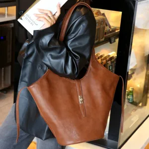 Detail view of the brown leather tote bag, featuring a chic metal lock and spacious design.