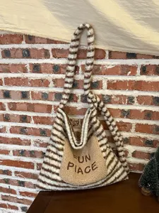 Close-up of fluffy striped shoulder tote bag with cute embroidered front pocket detail.