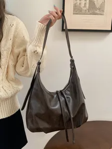 Vista dettagliata della borsa hobo marrone scuro, con morbida pelle PU e spallaccio.