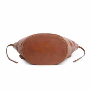 Detailed view of the brown leather bag bottom showing sturdy stitching and oval shape.