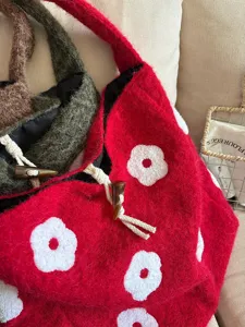 Close-up detail of cozy plush flower embroidered bucket tote bag with cute toggle drawstring.