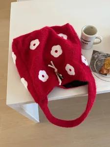 Detailed view of the red fluffy plush bucket bag featuring white floral embroidery and cozy style.