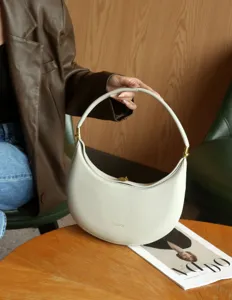 Detailed view of the stylish cream white crescent hobo bag with gold hardware for daily use.