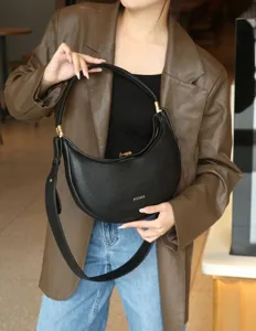 Black crescent underarm bag for women, stylish leather shoulder handbag with gold hardware.