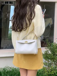 Vue détaillée d'un sac à main en cuir PU blanc au design rétro et détails dorés.