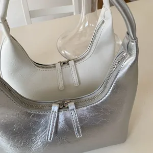 Glossy soft leather hobo crescent shoulder bag detail with double metal zippers.