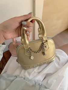 Chic metallic gold dome handbag for women, featuring chic studs and playful dice chain charms.