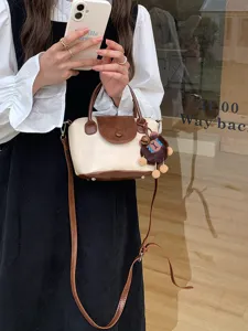 Stylish contrast color shoulder handbag with cute plush pendant, perfect for daily fashion wear.