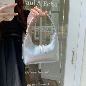 Silver metallic crescent underarm bag, glossy soft leather handbag detail showcase.