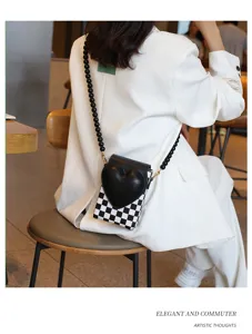 Schicke schwarz-weiße karierte Mini-Handytasche mit Perlenarmband und stilvollem Herzdetail.