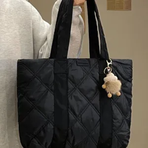 Black quilted puffer tote bag with cute doll charm, large capacity casual shoulder handbag.