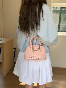Pink patent leather dome shoulder bag with metal studs and chain charm detail view